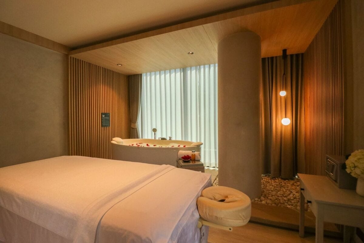 Treatment room with massage bed and bathtub at Makkha Health & Spa Bangkok (BTS Asok)